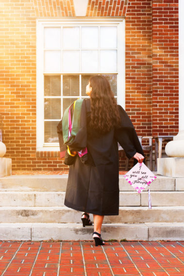 Graduate walking up the steps at Texas Women's University building